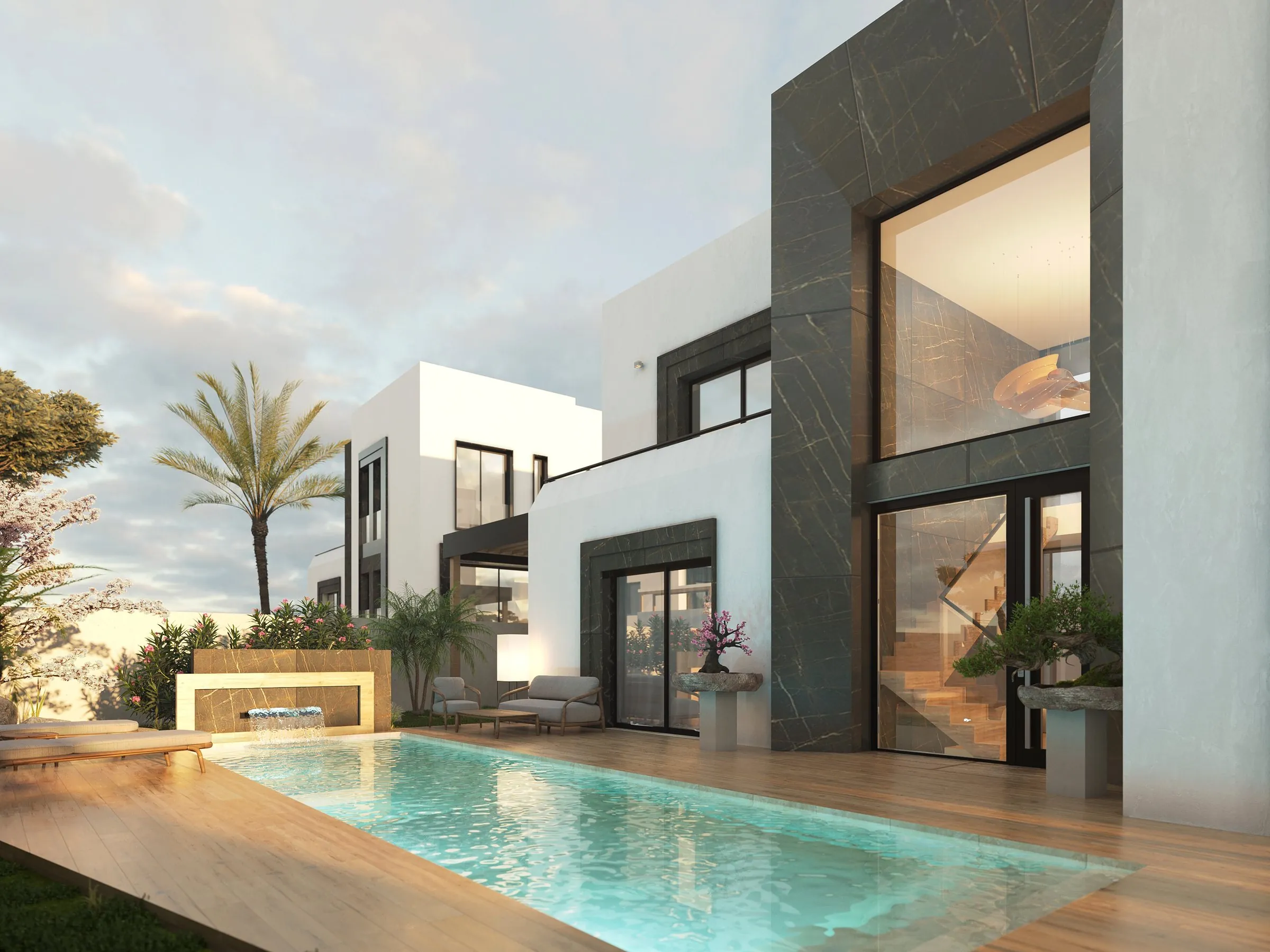Pool façade of a Sakura Garten villa at dusk — dark stone double-height volume, glazing and warm interior light